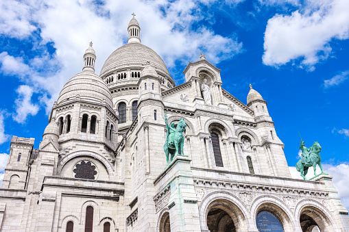 Low angle view on Sacred Heart Church against cloudy blue sky in Paris, France