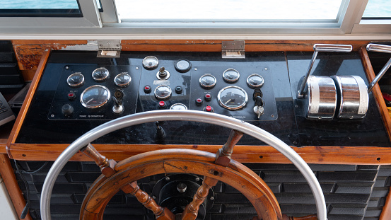 Steering wheel in the captain cabin of a big tour boat or ferry. Inside the captain's cabin. transportation and travel concept