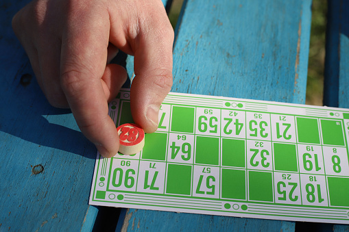 Lotto board game for friends and family. bingo. retro cards of bright different colors with numbers lie on a blue wooden surface