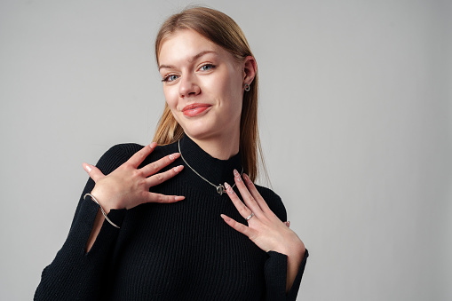 Smiling Woman in Black Top against gray background in studio