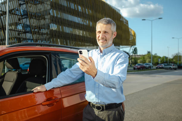 istock Mature man using smart phone by the parked car 2148696288