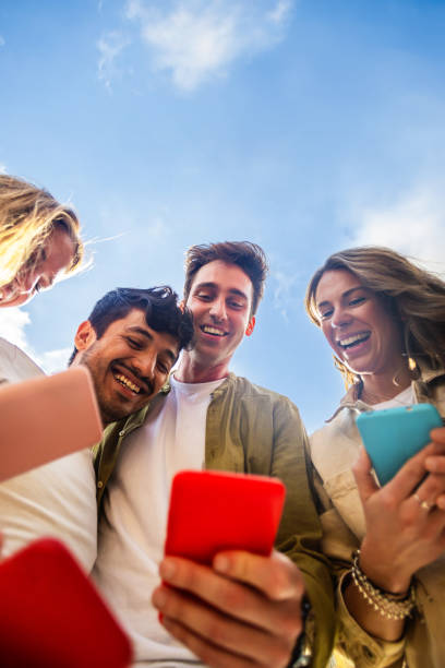 istock Young people using mobile phone device standing in circle outdoors 2148696707