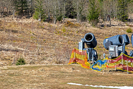 non-working snow generator on a slope without snow gear at a resort on a sunny day. Active recreation
