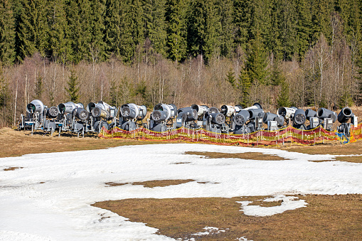 non-working snow generator on a slope without snow gear at a resort on a sunny day. Active recreation