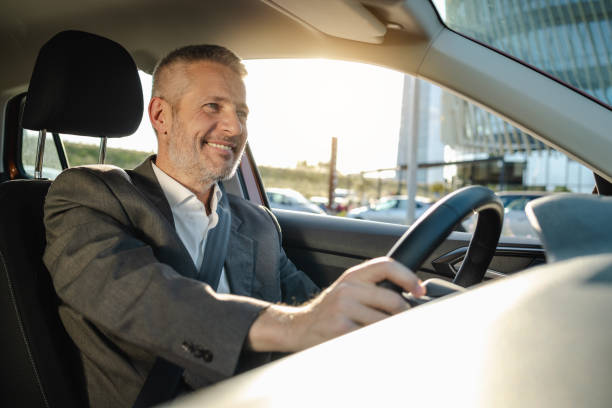 istock Smiling mature businessman driving his car 2148697178