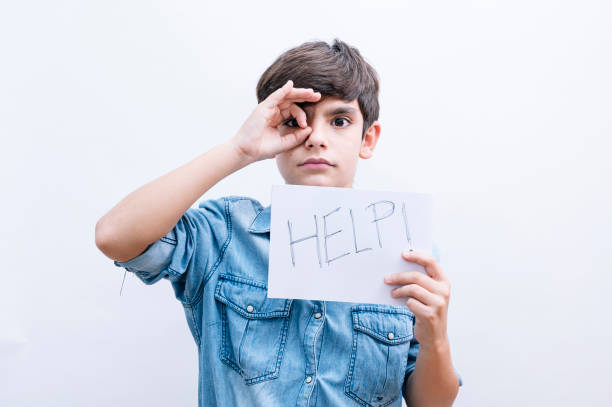 istock Young little boy kid holding paper sing with help message asking for protection 2148698081