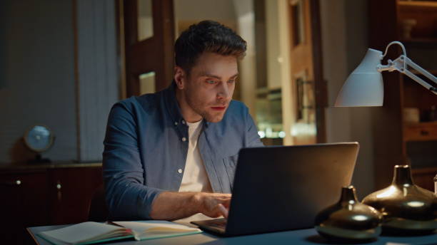istock Focused man staring computer reading email at dark flat closeup. Excited winner 2148698166