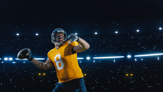 Aesthetic Shot of Athletic American Football Player Throwing a Ball on Black Background Under Spotlight. Professional Caucasian Athlete Plays Successful Pass With Teammates During Championship Final