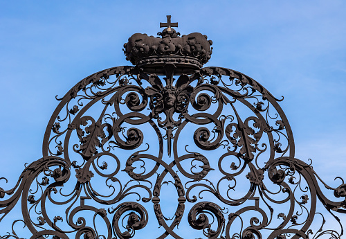 Sumptuous wrought iron interlaced grill above historical 18th century street gate against clear sky for copy space. Outside gate of Belvedere public gardens in Vienna, Austria