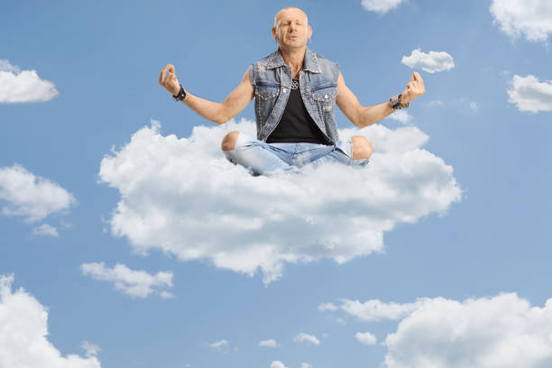 istock Bald man sitting corssed legged and practicing meditation up in the sky 2148701228