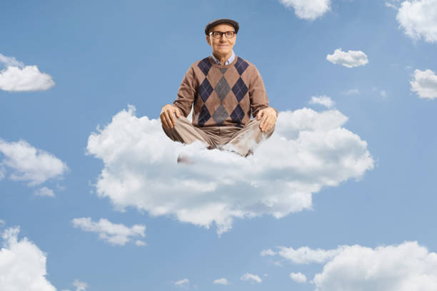 istock Elderly man sitting on a cloud in a yoga pose 2148701232
