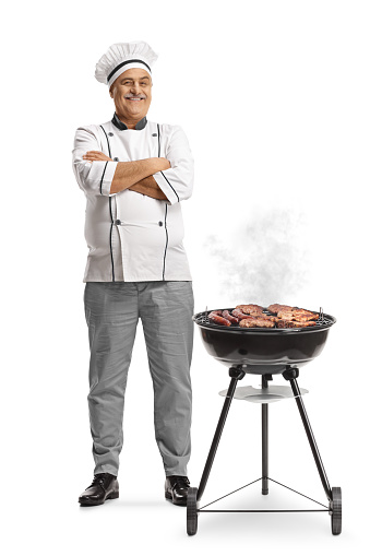 Chef next to a portable barbecue grill isolated on white background