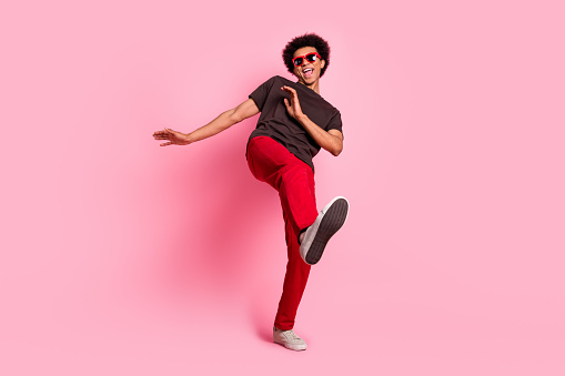 Full length body photo of cool macho carefree guy in trendy apparel chill out positive relaxing dance isolated on pink color background.