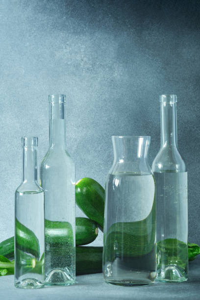 istock Glass water bottles and fresh green zucchini on a textured gray surface 2148703288