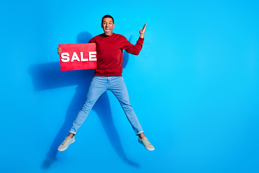 Full body profile photo of handsome cheerful man jump run empty space isolated on blue color background.