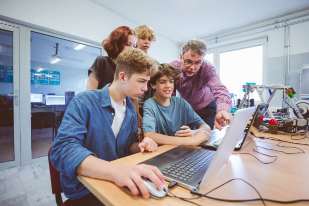 istock High school student and male teacher learing programming 2148705639