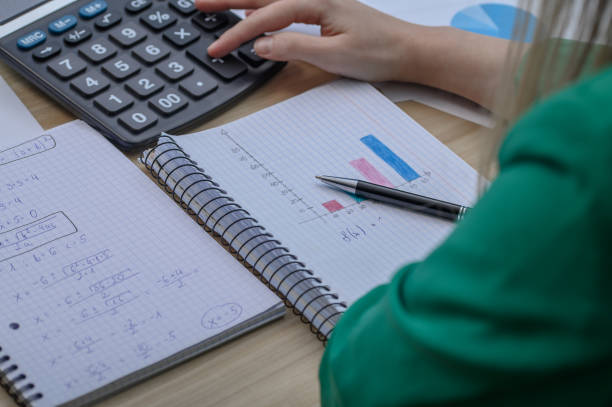 istock A woman sits at a desk over papers and counts expenses 2148706665