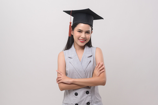 Young smiling woman wearing graduation hat, education and university concept