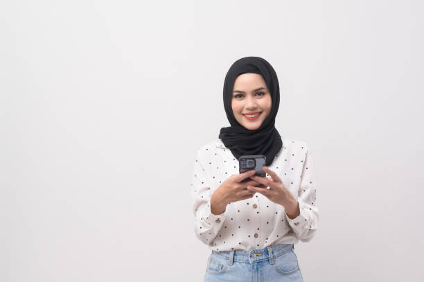 istock Beautiful musllim woman with hijab using smartphone over white background, technology concept. 2148707610