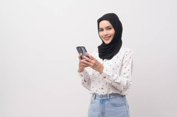 istock Beautiful musllim woman with hijab using smartphone over white background, technology concept. 2148707653