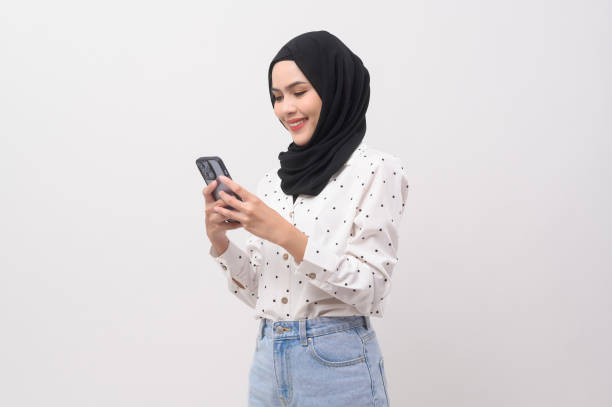 istock Beautiful musllim woman with hijab using smartphone over white background, technology concept. 2148707696