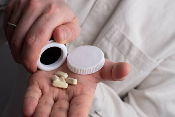 istock Pill close-up on a white background in a hand. Taking vitamins or medications. The concept of healthcare, medicine, pharmacies, disease prevention 2148710149
