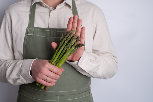 Green asparagus in the hands of a men. Bunch of ripe fresh asparagus. Healthy organic food. Cooking in home. Natural vitamins, raw ingredient for eating. Handpicked bio asparagus