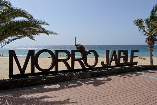 Jandia / Morro Jable, Fuerteventura, Spain, February 18, 2024 - Morro Jable town sign on the sandy beach of Jandía, Fuerteventura, Canary Islands.
