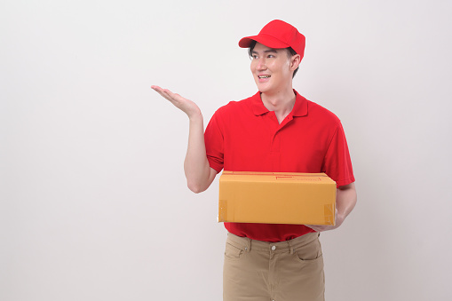Asian Young delivery man wearing  red uniform on  white background studio