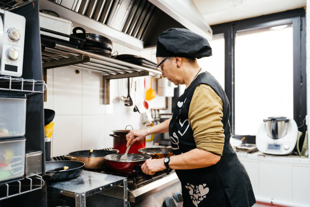 istock Female Chef Prepares Meal in a Bright Professional Kitchen During a Busy Workday 2148710474