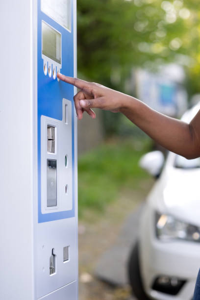 istock A woman's bronzed-skinned hand presses buttons on a parking ticket vending machine. 2148711099