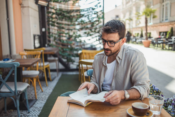 istock A young man is reading a book while sitting in the garden of a cafe 2148713068