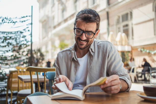 istock A young man is reading a book while sitting in the garden of a cafe 2148713082