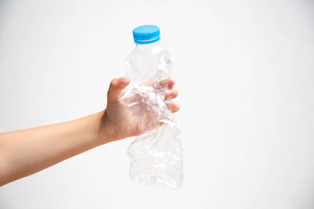 Kid hand holding a waste plastic drinking bottle; concept of recycle