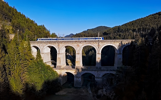Passenger train rides on famous Kalte Rinne Viaduct on historical Semmering railway (Semmeringbahn), Lower Austria.