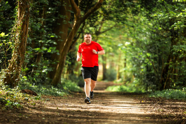 istock Mid adult man jogging on forest path 2148714386