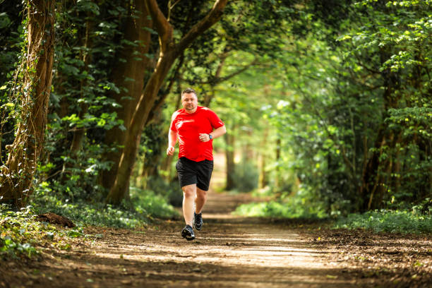 istock Mid adult man jogging on forest path 2148714397