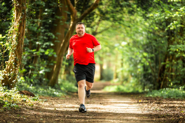 istock Mid adult man jogging on forest path 2148714425