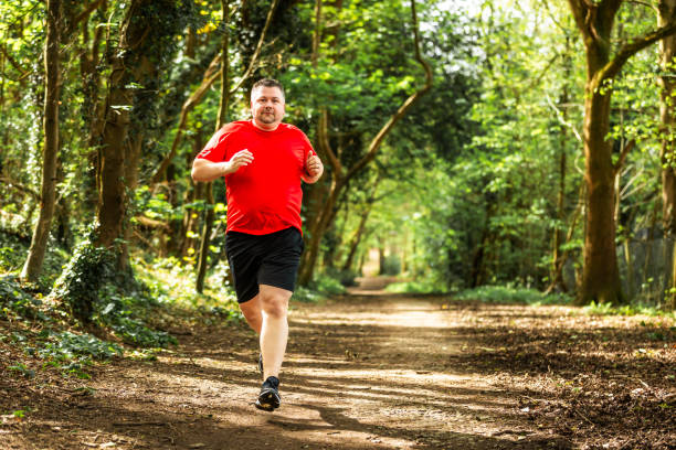 istock Mid adult man jogging on forest path 2148714428