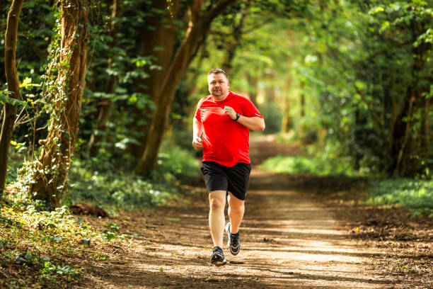 istock Mid adult man jogging on forest path 2148714466