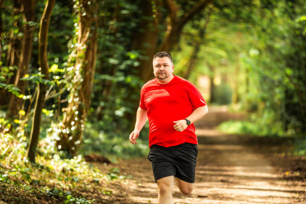 istock Mid adult man jogging on forest path 2148714468