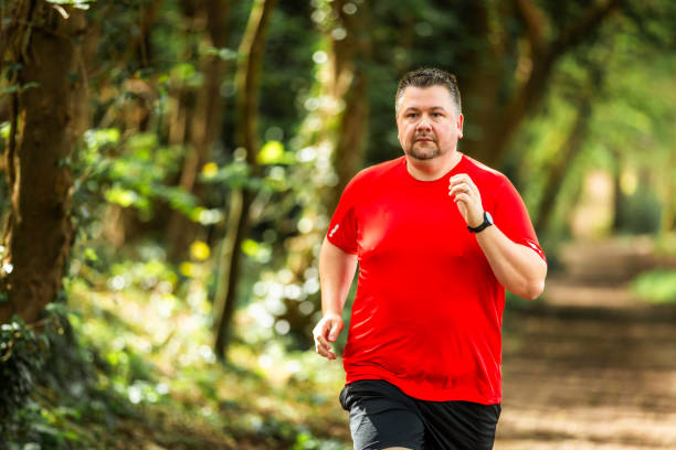 istock Mid adult man jogging on forest path 2148714498