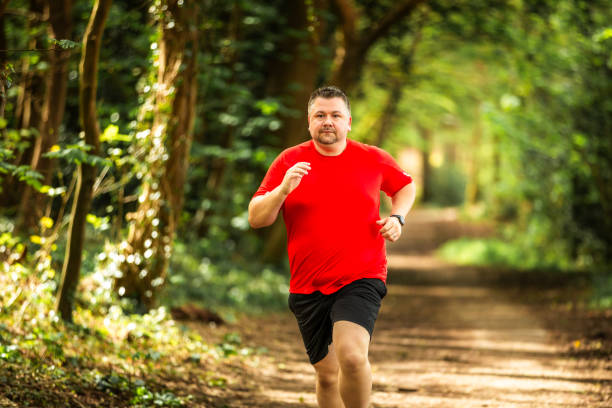 istock Mid adult man jogging on forest path 2148714501