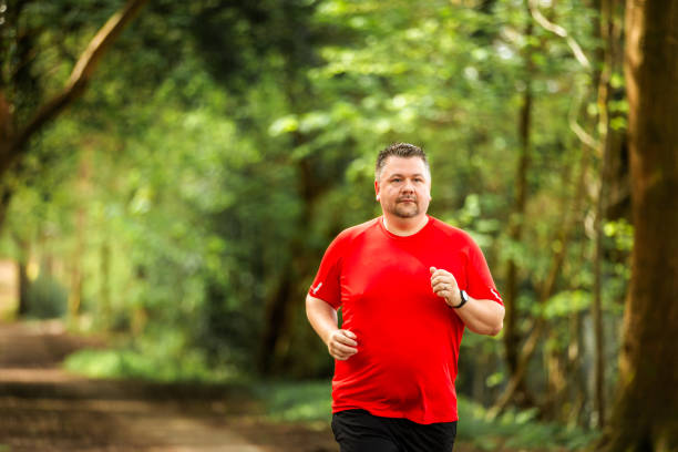 Mid adult man jogging on forest path