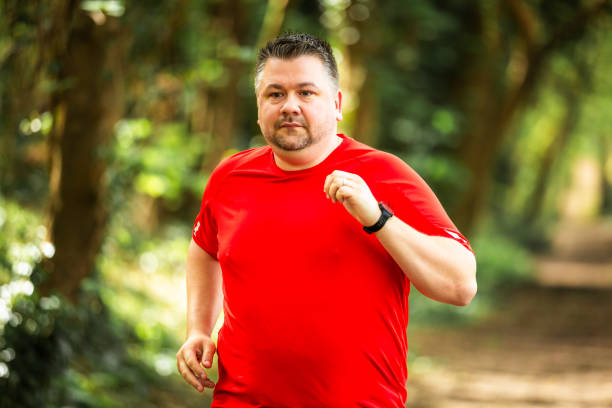 istock Mid adult man jogging on forest path 2148714505