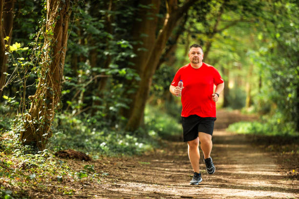 istock Mid adult man jogging on forest path 2148714542