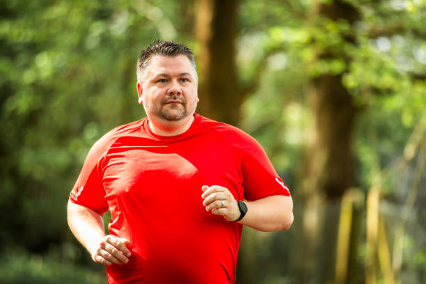 istock Mid adult man jogging on forest path 2148714544