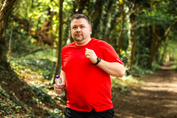 istock Mid adult man jogging on forest path 2148714550