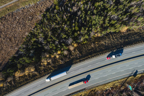 Aerial drone view of semi trucks on a multi-lane highway.