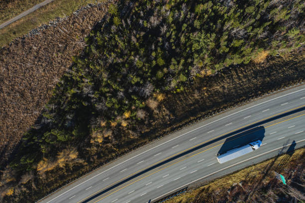 Aerial drone view of a semi truck on a multi-lane highway.